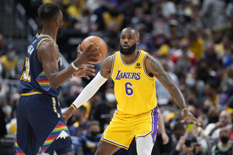 Denver Nuggets forward Jeff Green, front, looks to pass the ball as Los Angeles Lakers forward LeBron James defends in the first half of an NBA basketball game Saturday Jan. 15, 2022, in Denver. (AP Photo/David Zalubowski)