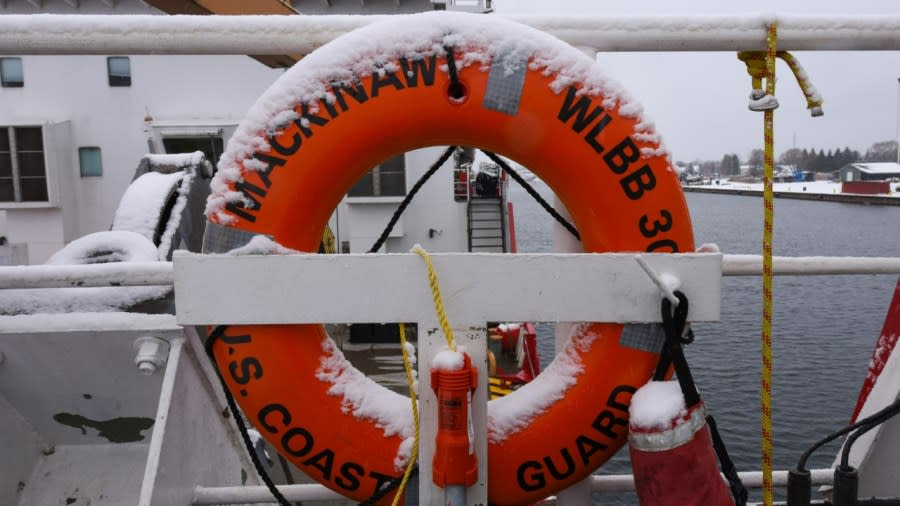 An orange life ring is coated with snow. It reads "U.S. Coast Guard Mackinaw WLBB 30."
