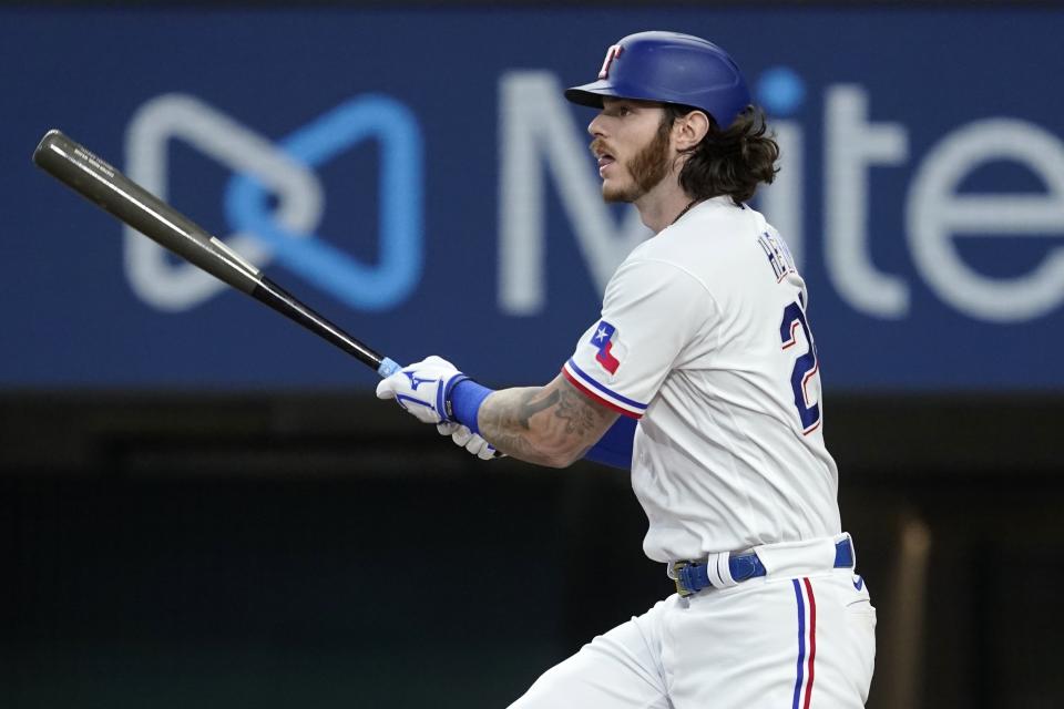 Texas Rangers' Jonah Heim follows through on a run-scoring single in the sedond inning of a baseball game against the Seattle Mariners, Saturday, July 16, 2022, in Arlington, Texas. Nathaniel Lowe scored on the play. (AP Photo/Tony Gutierrez)