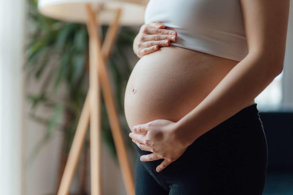 <p>Getty</p> Stock image of pregnant woman touching her belly. 