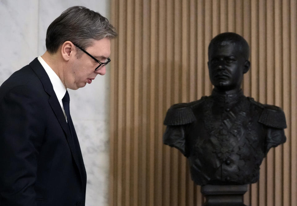 Serbian President Aleksandar Vucic walks by a bust of the former Serbian King Aleksandar Obrenovic as he arrives at a press conference after meeting with European Union envoy Miroslav Lajcak, in Belgrade, Serbia, Friday, Jan. 20, 2023. Western envoys on Friday were visiting Kosovo and Serbia as part of their ongoing efforts to defuse tensions and help secure a reconciliation agreement between the two. (AP Photo/Darko Vojinovic)
