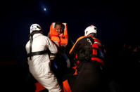 Rescuers of the Malta-based NGO Migrant Offshore Aid Station (MOAS) rescue migrants from a rubber dinghy in the central Mediterranean in international waters off the coast of Sabratha in Libya, April 15, 2017. REUTERS/Darrin Zammit Lupi