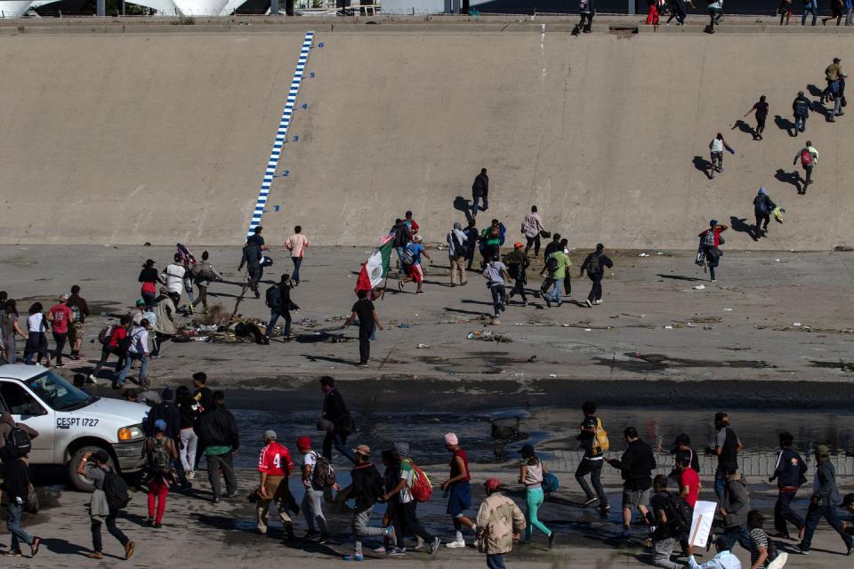 <p>Central American migrants -mostly from Honduras- cross the shallow concrete waterway of the bordering Tijuana River as they try to reach the El Chaparral border crossing point in Tijuana, Baja California State, Mexico, on November 25, 2018.</p>
