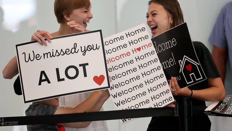 Wesley Titensor, Hannah Jackson and Sadie Jackson hold signs as they wait for Elder McCade Cefalo to arrive after serving a mission, at the Salt Lake City International Airport in Salt Lake City on Tuesday, June 20, 2023.