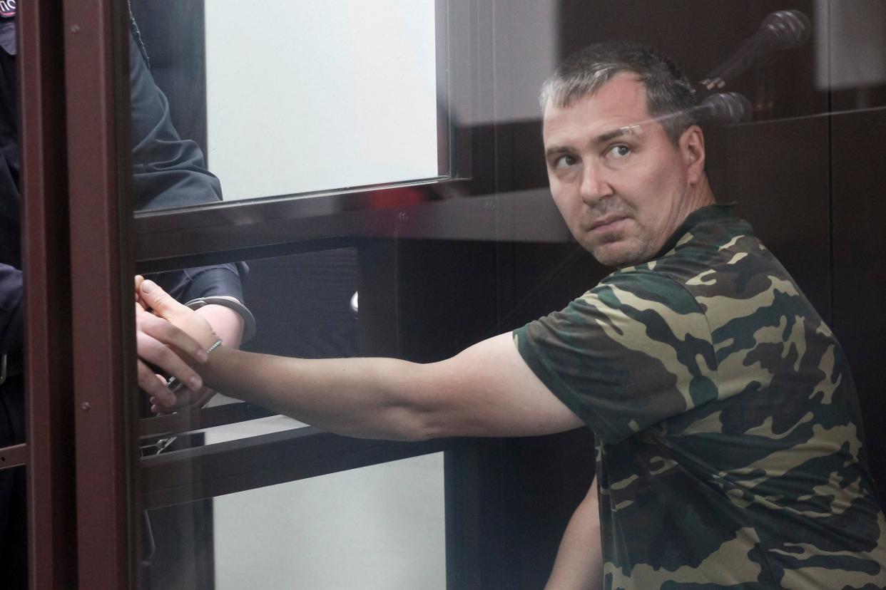 Alexander Popov, a man who was arrested on suspicion of murder sits behind the glass in a courtroom in the city of Gorodets, 60 km. (36 miles) north-west of Nizhny Novgorod, Russia, Sunday, June 20, 2021. (AP)