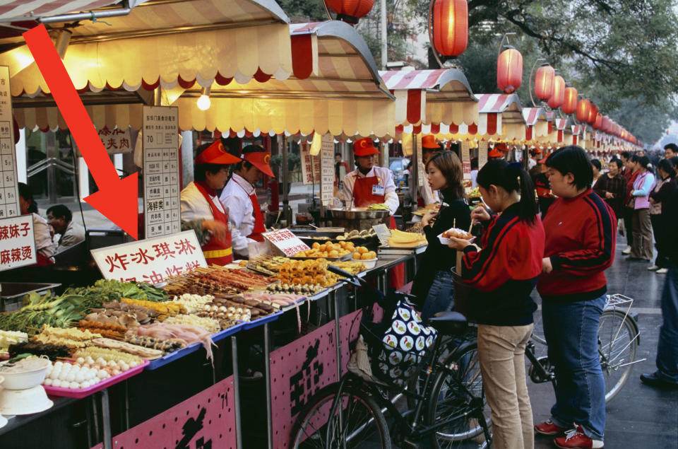 Food stands at a market in Beijing at dusk.