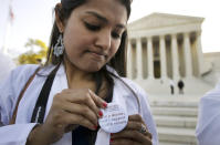 Dr. Sonia Nagda puts on a pin supporting the health care reform law as she gathers with other health care professionals.