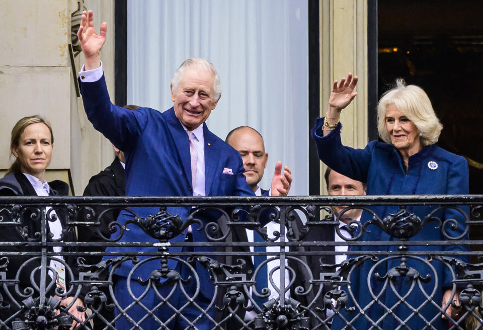 King Charles III and Camilla the Queen Consort, greet well wishers from a balcony