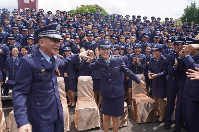 三軍八校院聯合畢典  畢業生與空軍司令比愛心 「113年三軍八校院聯合畢業典禮」27日上午在國防 大學復興崗校區舉行，畢業生開心與空軍司令劉任遠 上將（前左）合比愛心。 中央社記者徐肇昌攝  113年6月27日 