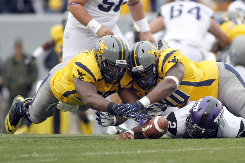 Will Clarke #98 and Shaq Rowell #90 of the West Virginia Mountaineers dive for a loose ball against Trevone Boykin #2 of the TCU Horned Frogs during the game on November 3, 2012 at Mountaineer Field in Morgantown, West Virginia. (Photo by Justin K. Aller/Getty Images)