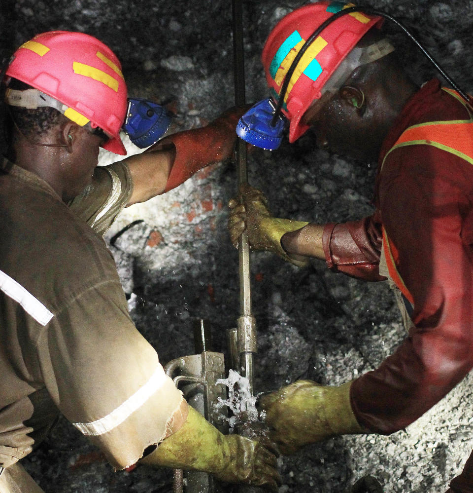 In this photo taken Thursday, Feb. 20, 2014, mine workers operate a rock driller at South Deep, 45 km south-west of Johannesburg. Miners work some 2.4 kilometers (1.5 miles) underground in 12-hour shifts, where safety is a constant concern and everyone depends on everyone else to stick to precautions. (AP Photo/Themba Hadebe)