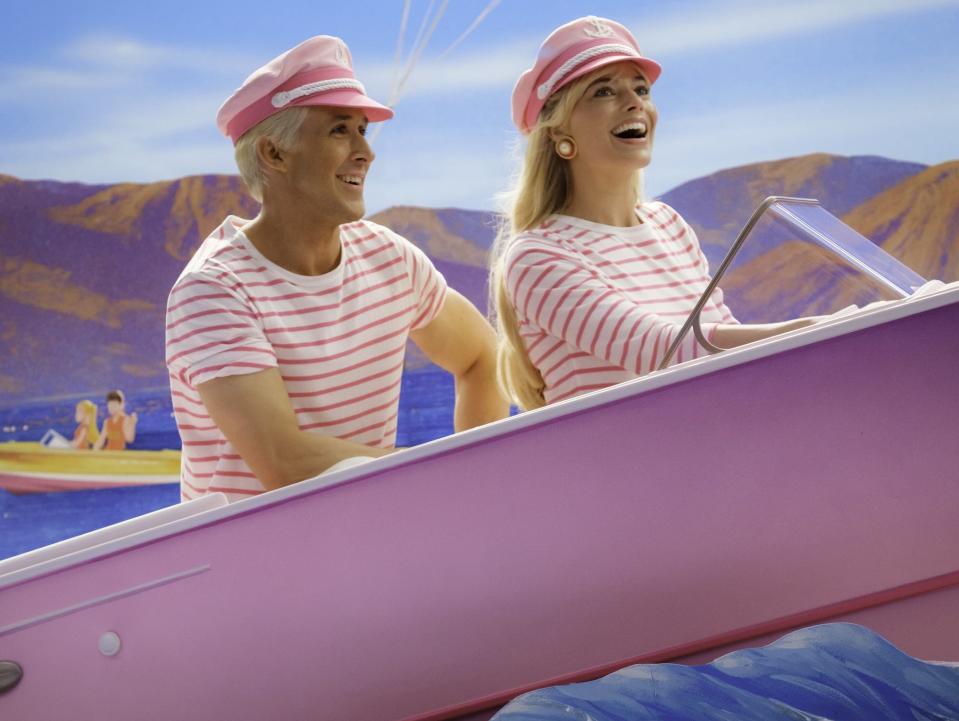 Ryan Gosling and Margot Robbie as Barbie and Ken in "Barbie" on a pink boat in a fake ocean.
