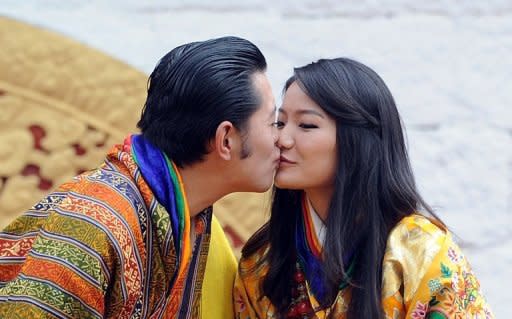 Bhutanese King Jigme Khesar Namgyel Wangchuck kisses Queen Jetsun Pema during a ceremony at the main stadium in Thimphu on October 15, 2011, a day after their marriage in Bhutan. Bhutan's rare form of polygamy, in which men or women take several sisters or brothers as partners, is dying out as the kingdom modernises, with this week's royal wedding another sign of its demise
