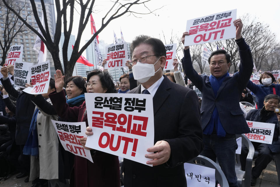 South Korea's main opposition Democratic Party leader Lee Jae-myung, center, holds a banner during a rally against the South Korean government's move to improve relations with Japan in Seoul, South Korea, Wednesday, March 1, 2023. South Korea's president on Wednesday called Japan "a partner that shares the same universal values" and renewed hopes to repair ties frayed over Japan's colonial rule of the Korean Peninsula. The banner reads "South Korean President Yoon Suk Yeol's humiliation diplomacy." (AP Photo/Ahn Young-joon)