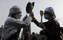 Hospitality workers beat their pans to protest in Parliament Square in London, Monday, Oct. 19, 2020. Hospitality workers are demonstrating outside Parliament against tougher coronavirus restrictions and the amount of financial support given by the government to the industry.(AP Photo/Frank Augstein)