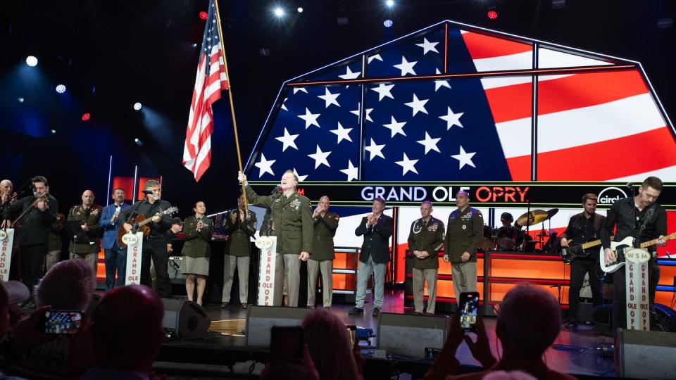 Country music star Craig Morgan (center) sings after re-enlisting on stage during a ceremony at his Nashville, Tenn., concert on July 29. (Chris Hollo/Grand Ole Opry)