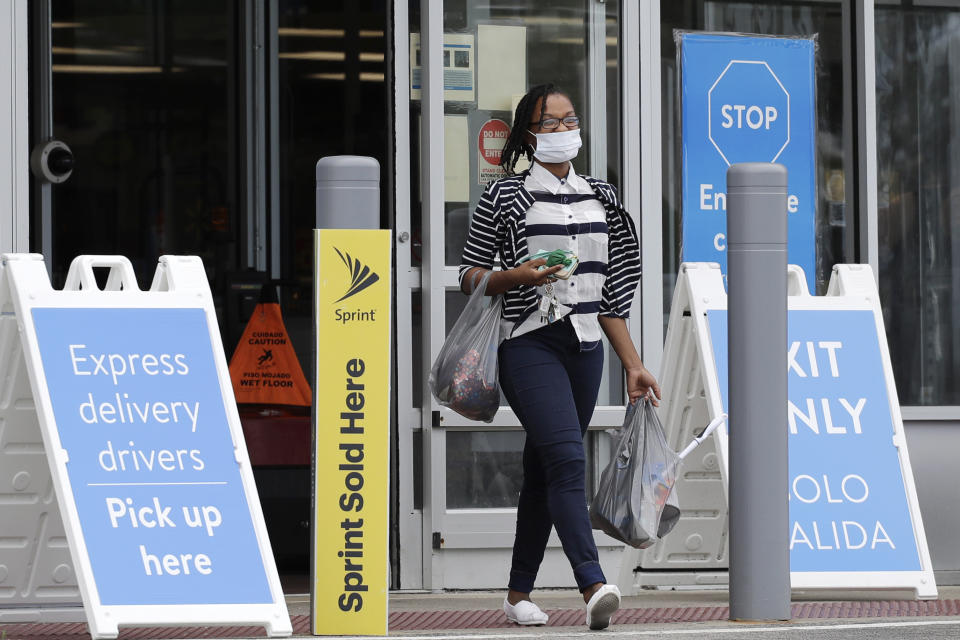 A shopper wears face masks as she leaves a Walmart retail store in Vernon Hills, Ill., Thursday, July 30, 2020. Many retail stores are requiring customers to wear face masks inside all of their stores where local governments do not require it amid the coronavirus pandemic. However, limited enforcement, at Walmart avoids physical confrontations with customers who refuse to wear a mask. (AP Photo/Nam Y. Huh)