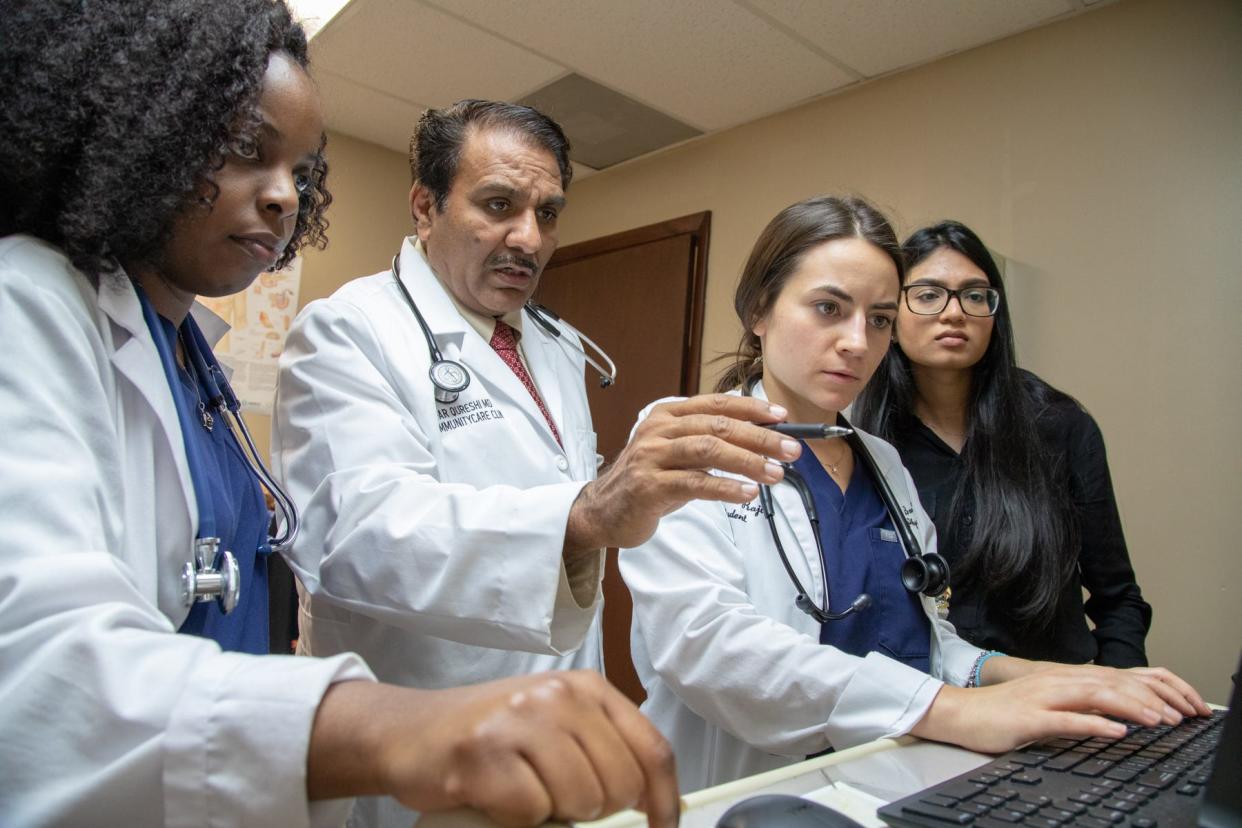 A health care team at a Miami clinic confers via video call with one of MAVEN’s physician volunteers.