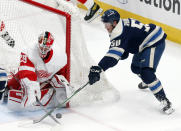 Detroit Red Wings goalie Thomas Greiss, left, stops a shot by Columbus Blue Jackets forward Eric Robinson during the first period of an NHL hockey game in Columbus, Ohio, Friday, May 7, 2021. (AP Photo/Paul Vernon)