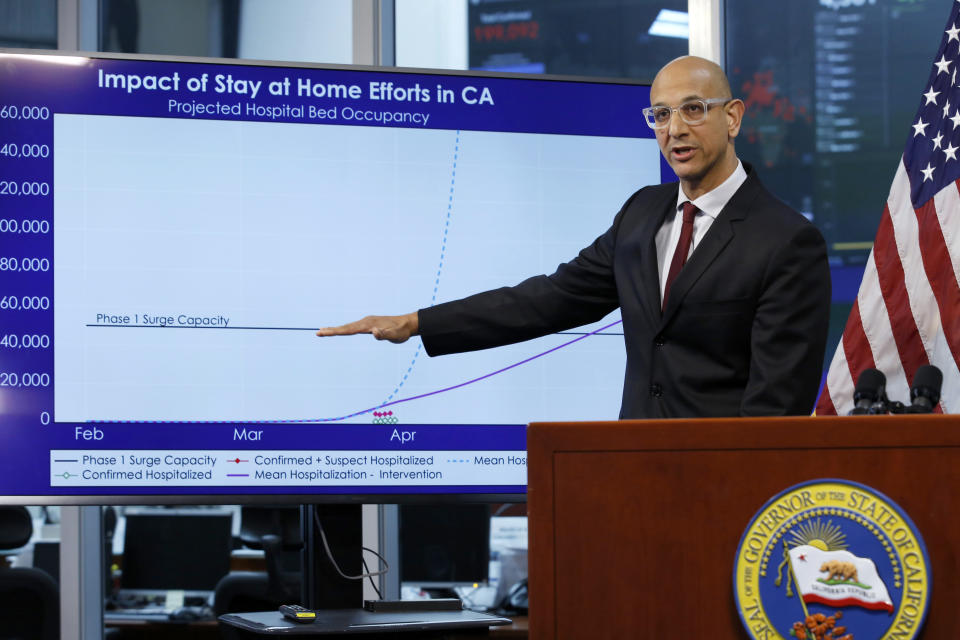 FILE - In this April 1, 2020, file photo Dr. Mark Ghaly, secretary of the California Health and Human Services, gestures to a chart showing the impact of the mandatory stay-at-home orders, during a news conference in Rancho Cordova, Calif. A steady drop in coronavirus cases across California cleared the way Tuesday, Sept. 22, 2020, for the wider reopening of businesses in nine counties, including much of the San Francisco Bay Area, the state's top health official said. Ghaly, said nail salons could also reopen with restrictions, though he cautioned that California's reopening must remain "slow and stringent" and residents cannot let their guard down as flu season arrives and cases rise in Europe and other parts of the U.S. (AP Photo/Rich Pedroncelli, Pool, File)