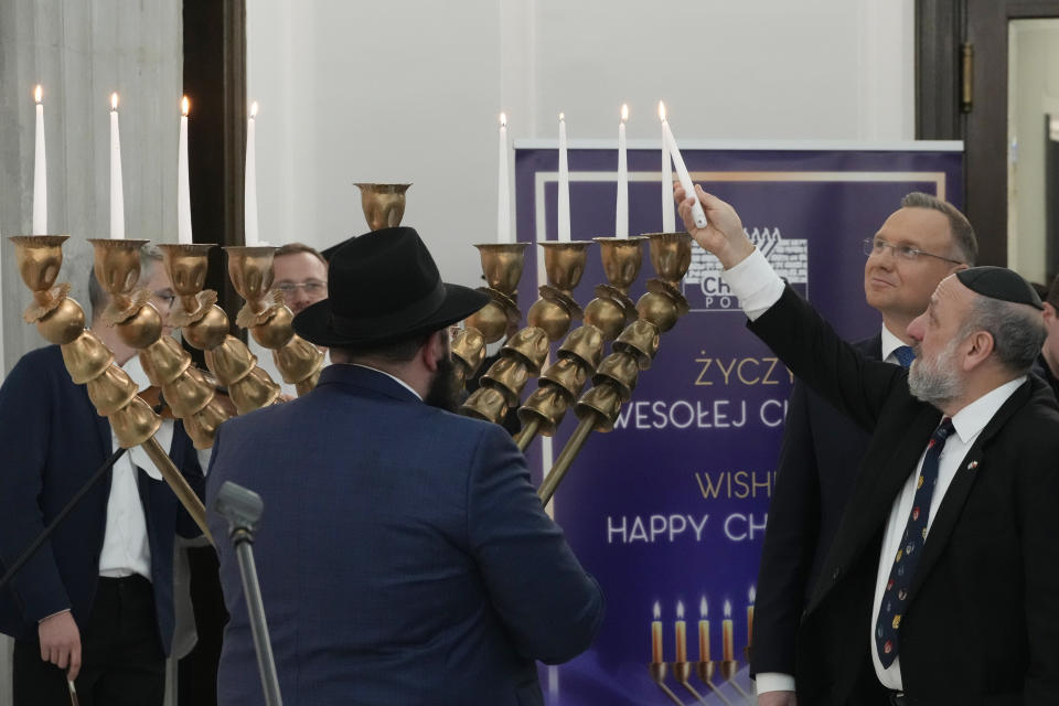 Members of parliament, President Andrzej Duda, second right, and the Polish Jewish community come together on the last night of Hanukkah for a candle lighting ceremony in parliament, in Warsaw, Poland, on Thursday Dec. 14, 2023. The ceremony was held to send a message of tolerance and to denounce antisemitism after a far-right lawmaker used a fire extinguisher to put out burning candles on a menorah. (AP Photo/Czarek Sokolowski)