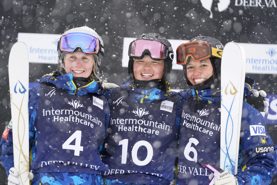 FILE - Kai Owens, center, celebrates after finishing first in the finals, between Hannah Soar, left, who finished second, and Tess Johnson, who placed third, in the World Cup women's dual moguls skiing competition Friday, Feb. 5, 2021, in Deer Valley, Utah. As an infant, she was abandoned at a town square in a province of China. Taken to an orphanage, she was adopted by a couple from Colorado at 16 months. Now 17, U.S. freestyle skier Kai Owens is on the verge of earning a spot in moguls for the Winter Games in Beijing. It's a return to China she's long thought about. (AP Photo/Rick Bowmer, File)