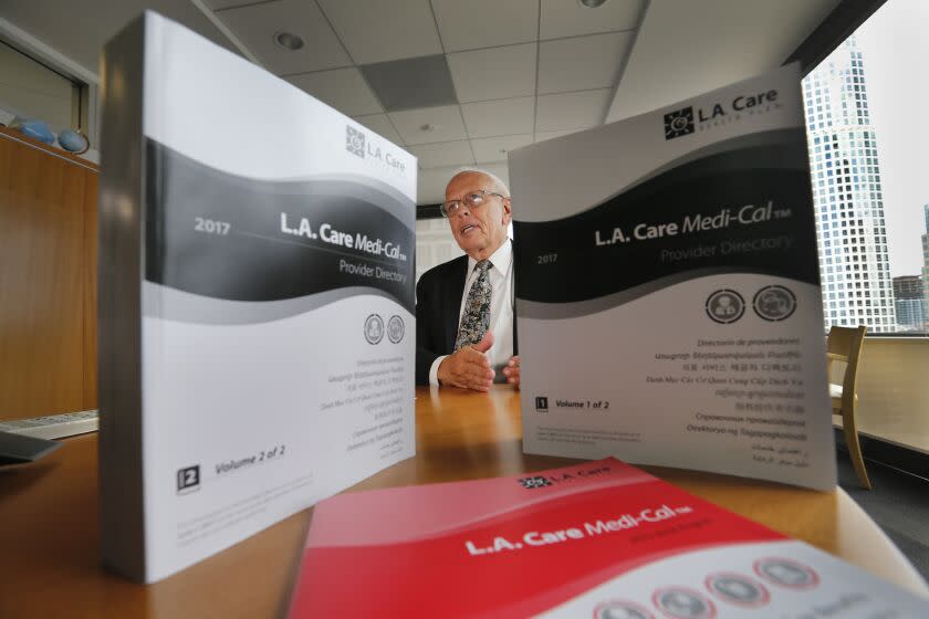 LOS ANGELES, CALIF. -- TUESDAY, AUG. 15, 2017: John Baackes, L.A. Care Health Plan, Chief Executive Officer, shown with two volumes of L.A. Care Medi-Cal provider directories: with a total of 3,894 combined pages, has been petitioning the state to allow them to stop sending the directories to 2 million Angelenos each year. California requires insurers to send each Medi-Cal beneficiary a phone-book-sized provider directory in the mail, even though a copy exists online. Many think it's an unnecessary multi-million dollar expense. Photos taken Tuesday, Aug. 15, 2017 at L.A. Care in Los Angeles. (Allen J. Schaben / Los Angeles Times)