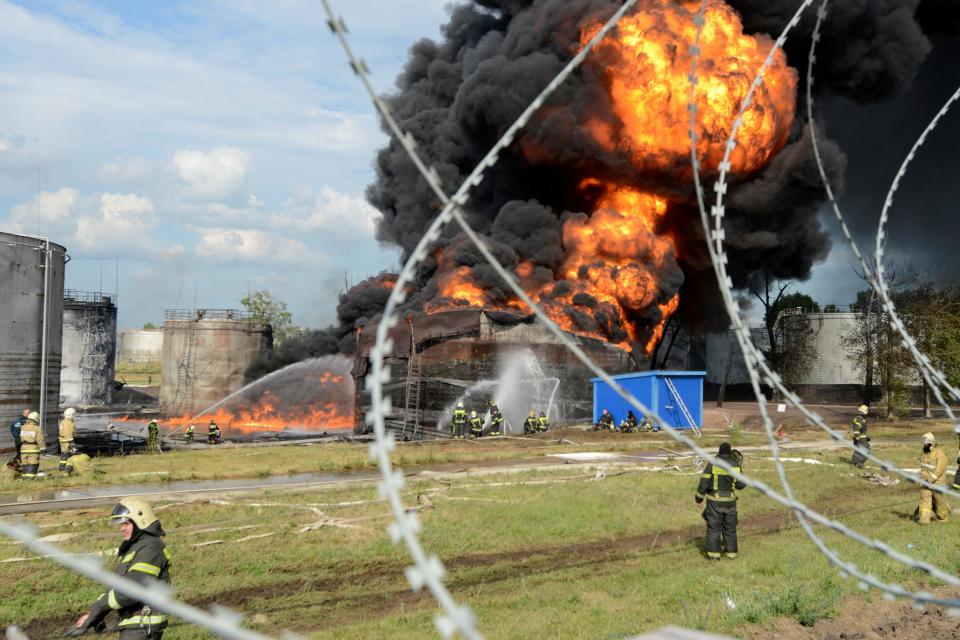 Emergencies ministry members work to extinguish fire at a burning fuel tank of an oil depot in Voronezh, (REUTERS)