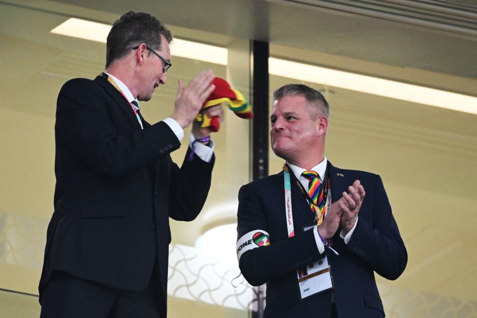 Stuart Andrew (R), the Welsh Parliamentary Under-Secretary of State for Sport, Tourism, Heritage and Civil Society, wears a rainbow armband and a rainbow tie while attending the Qatar 2022 World Cup Group B football match between Wales and England at the Ahmad Bin Ali Stadium in Al-Rayyan, west of Doha on November 29, 2022. (Photo by Ina Fassbender / AFP) (Photo by INA FASSBENDER/AFP via Getty Images)