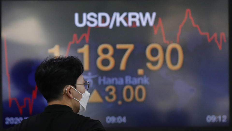 A currency trader walks by the screen showing the foreign exchange rate between U.S. dollar and South Korean won at the foreign exchange dealing room in Seoul, South Korea, Friday, Sept. 11, 2020. Asian shares were mixed Friday following a selloff of technology shares on Wall Street. (AP Photo/Lee Jin-man)