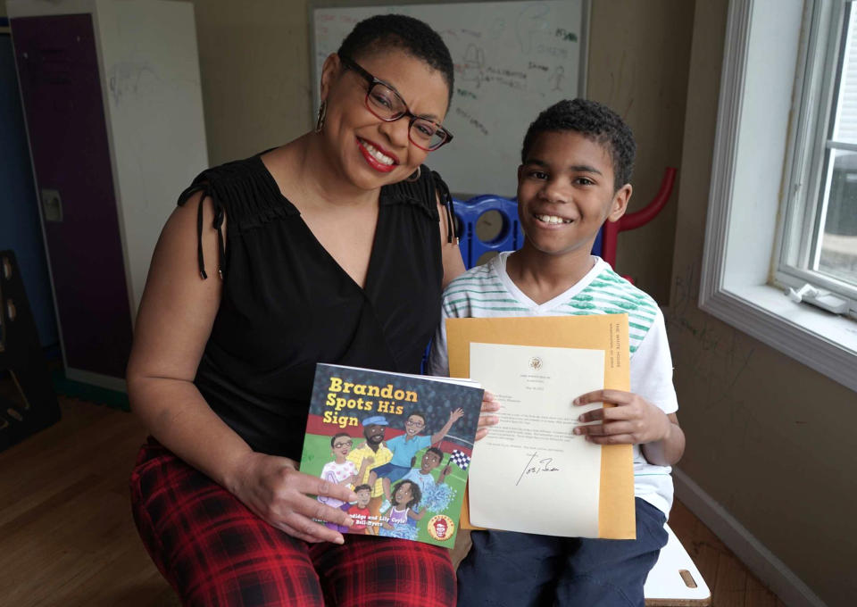 Sheletta Brundidge holds her book while her son, Brandon, holds a letter he received from President Joe Biden. (Courtesy Sheletta Brundidge)