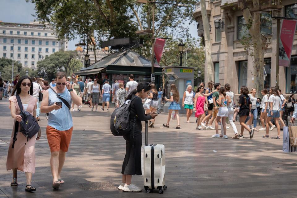People stroll along Las Ramblas on June 30, 2023, in Barcelona, Catalonia, Spain.