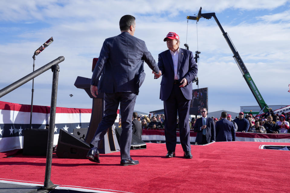 Republican presidential candidate former President Donald Trump, right, shakes hands with Bernie Moreno at a campaign rally Saturday, March 16, 2024, in Vandalia, Ohio. (AP Photo/Jeff Dean)