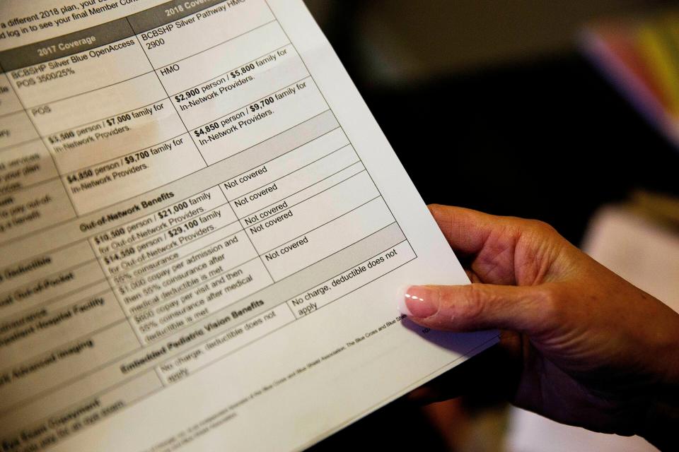 In this Monday, Dec. 4, 2017, file photo, a woman looks over her health insurance benefit comparison chart which shows out-of-network coverages dropped for 2018, at her home office in Peachtree City, Ga. (AP Photo/David Goldman, File)