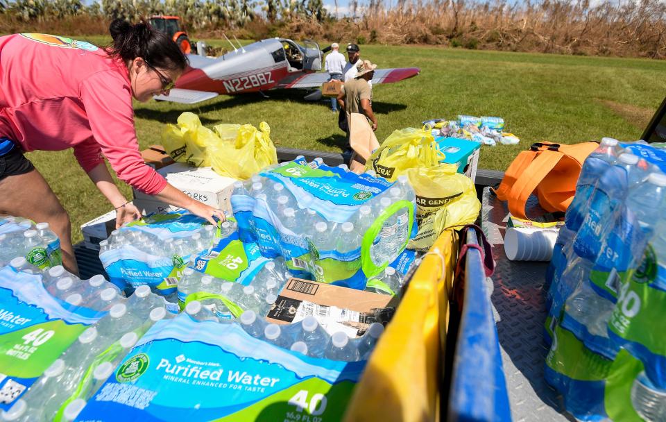 R2C2 volunteer Kinsey Morgan, left, organizes water as it is loaded onto a truck after being airlifted to Pine Island near Fort Myers, Fla., on Wednesday October 5, 2022. Hurricane Ian hit the southwest Florida coast on Wednesday September 28th.