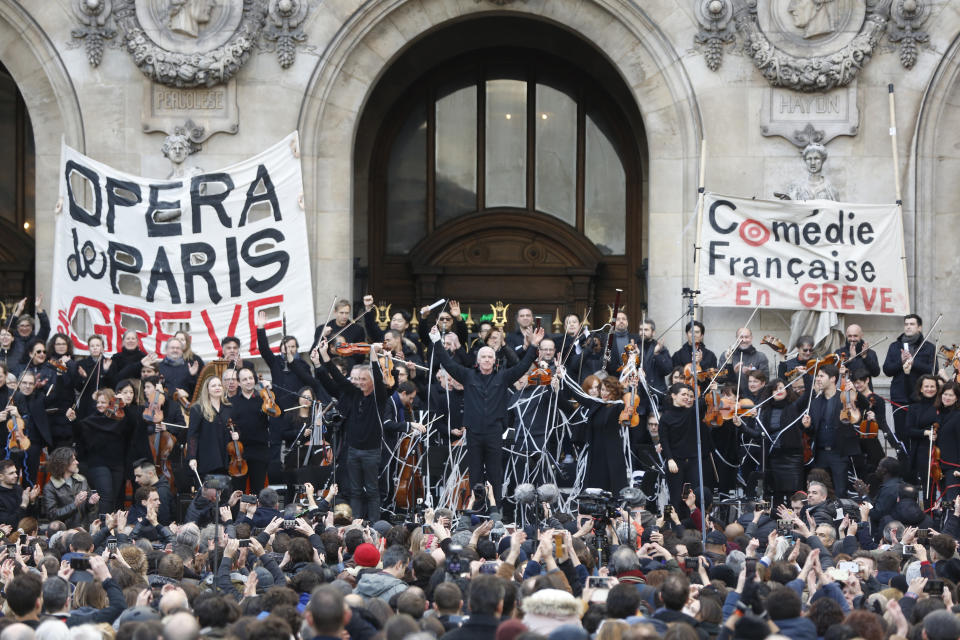 Striking opera musicians wave to the crowd after performing outside the Palais Garnier opera house, Saturday, Jan. 18, 2020 in Paris. As some strikers return to work, with notable improvements for train services that have been severely disrupted for weeks, more radical protesters are trying to keep the movement going. Musicians, singers and other members of the striking Paris Opera drew a crowd with a free concert in front of the Palais Garnier opera house. (AP Photo/Thibault Camus)