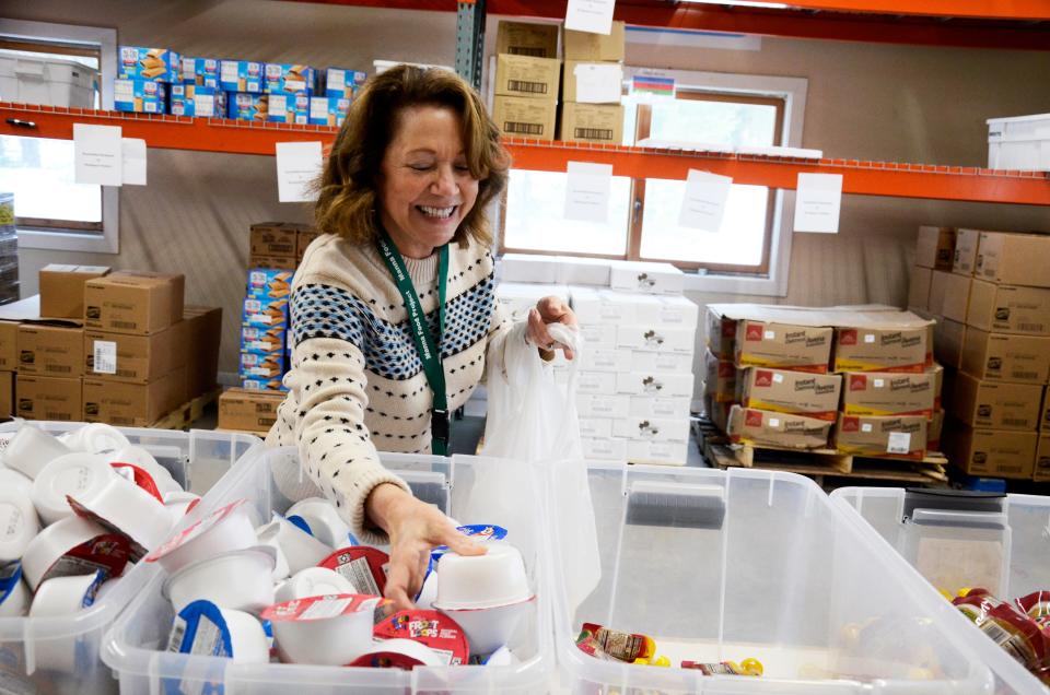 Volunteer Karen Quenneville helps pack snacks for the student backpack program on Thursday, Dec. 1 at the Manna Food Project in Harbor Springs.