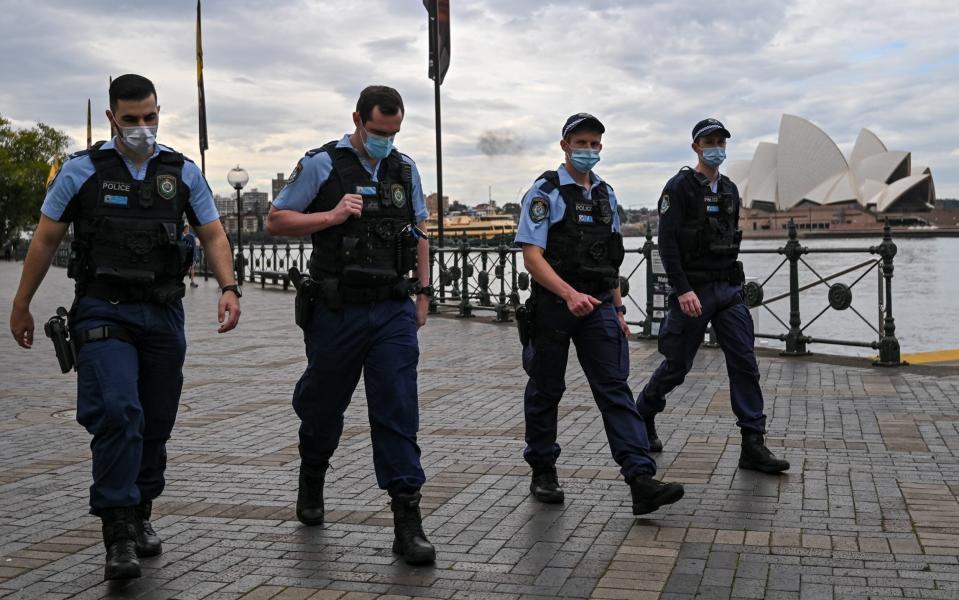 Police walk past the Sydney Opera House in Circular Quay, during lockdown in Sydney, Australia - Steven Saphore/Anadolu Agency via Getty Images