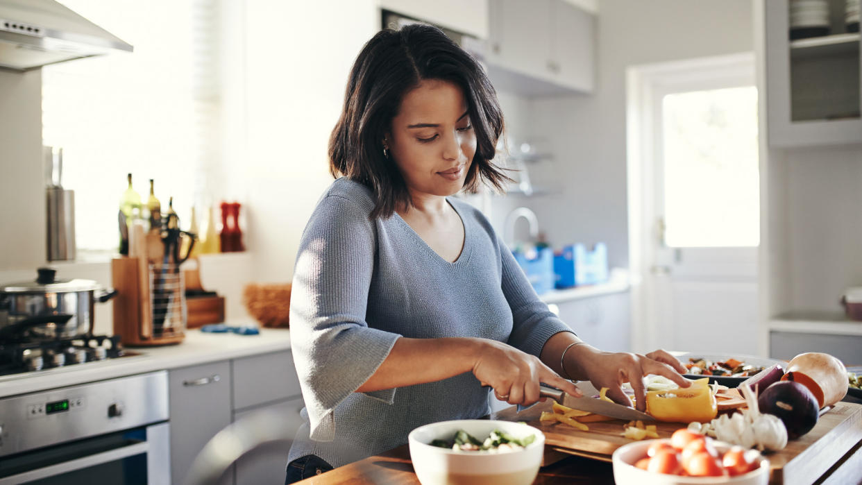 Shot of an attractive young woman cooking at home.