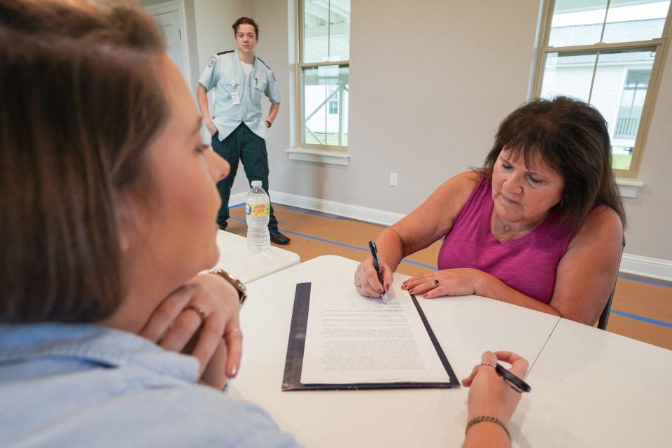 Bert Naquin signs the lease on her new home during an event to celebrate the first group of former residents of Isle de Jean Charles receiving the keys to their new homes at The New Isle resettlement community in Terrebonne Parish near Schriever, Louisiana, on August 24, 2022. - They are considered the first U.S. climate refugees since 2016. To relocate them, Louisiana received $48.3 million from a new federal program designed to anticipate the impacts of climate change. (Photo by Cécile Clocheret / AFP) (Photo by CECILE CLOCHERET/AFP via Getty Images)