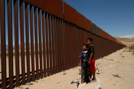 FILE PHOTO: Children stand by a new section of the border wall on the U.S.-Mexico border in this picture taken from Anapra neighborhood in Ciudad Juarez, Mexico May 3, 2018. REUTERS/Jose Luis Gonzalez/File Photo