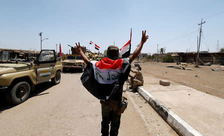 An Iraqi Shi'ite fighter gestures in the town of Garma, Iraq, May 26, 2016.REUTERS/Thaier Al-Sudani