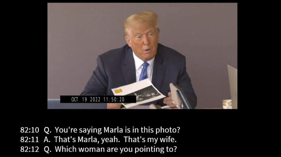 In this image taken from video released by Kaplan Hecker & Fink, former President Donald holds a photograph, presented as evidence during his Oct. 19, 2022 deposition, that shows E. Jean Carroll and her then-husband John Johnson meeting Trump and his wife Ivanka at an event in the 1980s. In his deposition, Trump mistook Carroll as Marla Maples, his now ex-wife, when shown the image. The video recording of Trump being questioned about the rape allegations against him was made public for the first time Friday, May 5, 2023, providing a glimpse of the Republican's emphatic, often colorful denials. (Kaplan Hecker & Fink via AP)