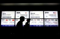 People walk past an electronic board displaying various Asian countries' stock price index and world major index outside a brokerage in Tokyo, Japan, August 21, 2015. REUTERS/Issei Kato/File Photo