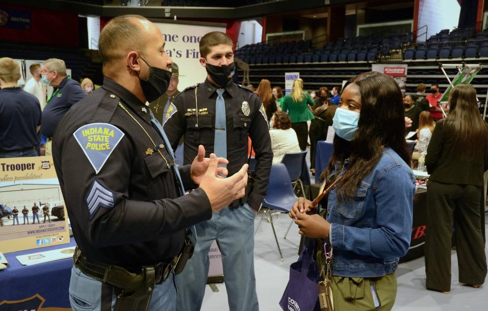 Sgt. Seth Rainey (left) and Trooper Tyler Widner (center) speak to 22-year-old criminal justice major Sheila Davis during a career fair at the University of Southern Indiana on March 2, 2022.