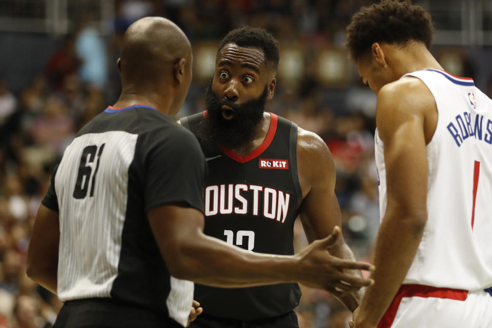 Houston Rockets shooting guard James Harden (13), center, reacts to a referee's call against him during the third quarter of an NBA preseason basketball game against the Los Angeles Clippers, Thursday, Oct 3, 2019, in Honolulu. (AP Photo/Marco Garcia)