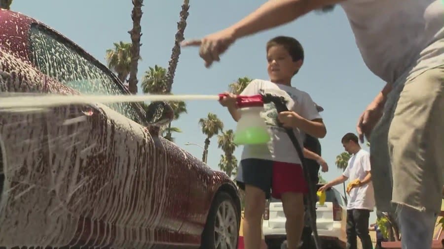 Anthony Brieno's son is seen helping out at a car wash fundraiser on July 6, 2024 to raise money for his father's funeral. (KTLA)