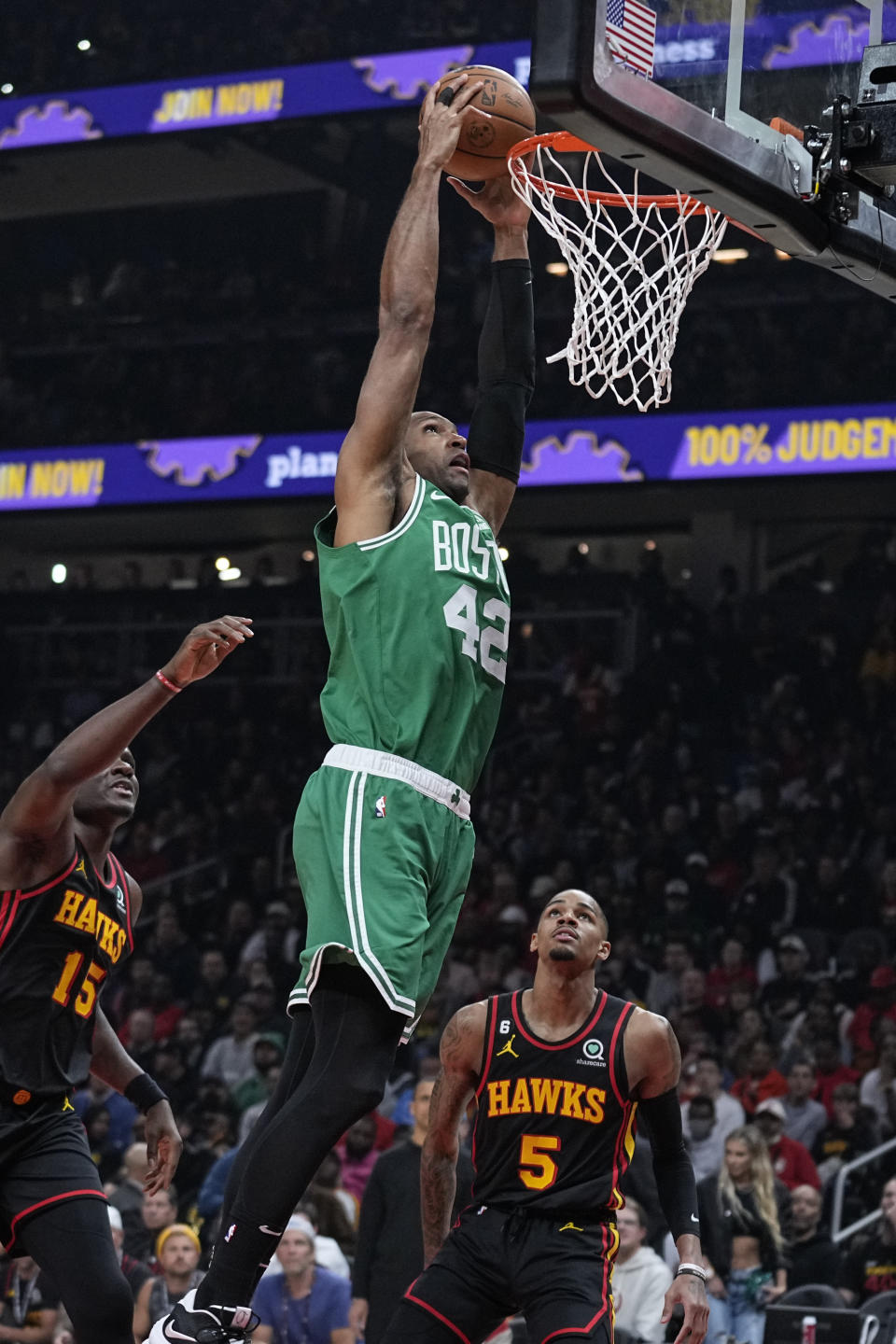 Boston Celtics center Al Horford (42) scores against Atlanta Hawks' Bogdan Bogdanovic (13) and Atlanta Hawks' Dejounte Murray (5) during the first half of Game 6 of a first-round NBA basketball playoff series, Thursday, April 27, 2023, in Atlanta. (AP Photo/Brynn Anderson)