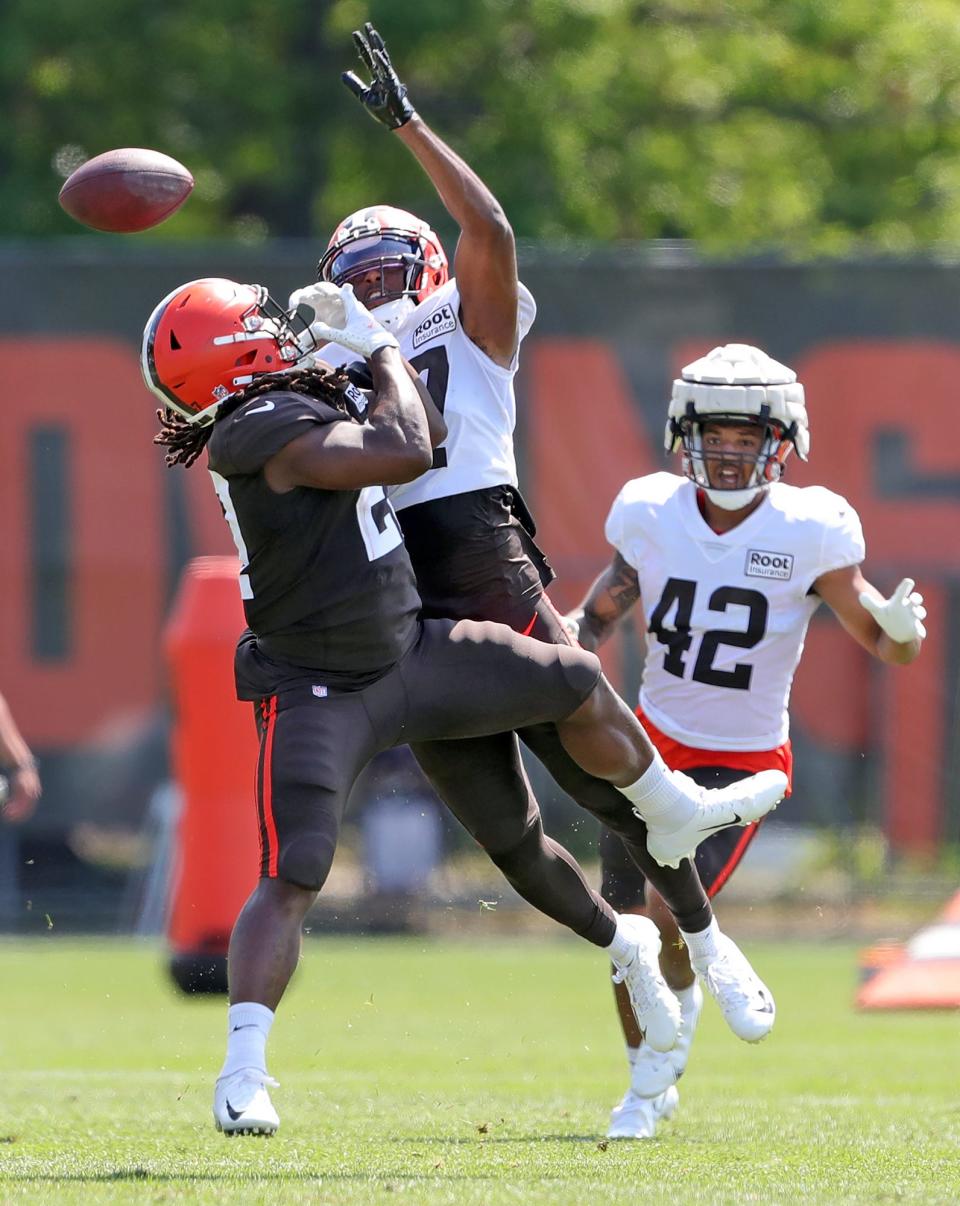 Cleveland Browns safety D'Anthony Bell, center, breaks up a pass intended for running back Kareem Hunt, left, during the NFL football team's football training camp in Berea on Tuesday.