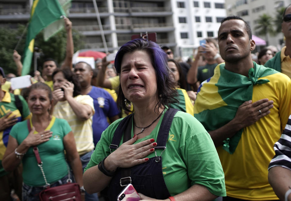 A supporter cries as she recites Brazil's national anthem during a rally in support of Brazil's President Jair Bolsonaro on Copacabana beach in Rio de Janeiro, Brazil, Sunday, May 26, 2019. The pro-Bolsonaro rally follows anti-government protests against cuts in the education budget as the leader also battles an uncooperative Congress, a family corruption scandal and falling approval ratings after five months in office. (AP Photo/Silvia Izquierdo)